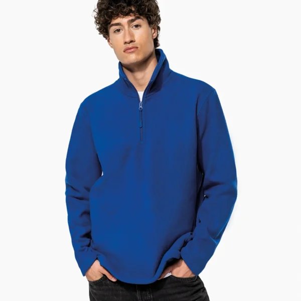 Man wearing a royal blue quarter-zip pullover with hands in pockets.
