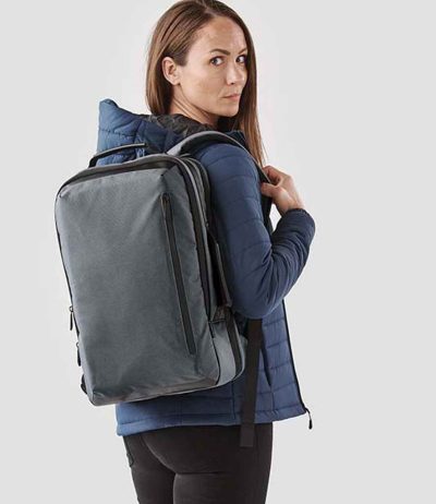 Professional woman with a KNX2 Stormtech Hedmark Commuter Backpack, an essential for the stylish commuter.